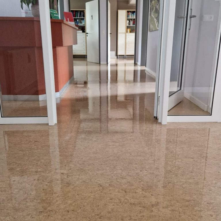 Ein heller Flur mit glattem Boden, der zu einem offenen Raum führt.